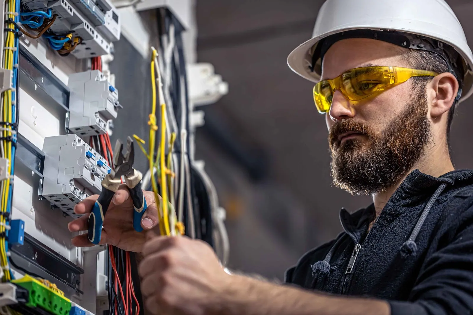 Elektricien werkt aan de bedrading van een schakelkast — IT-partner op de Veluwe