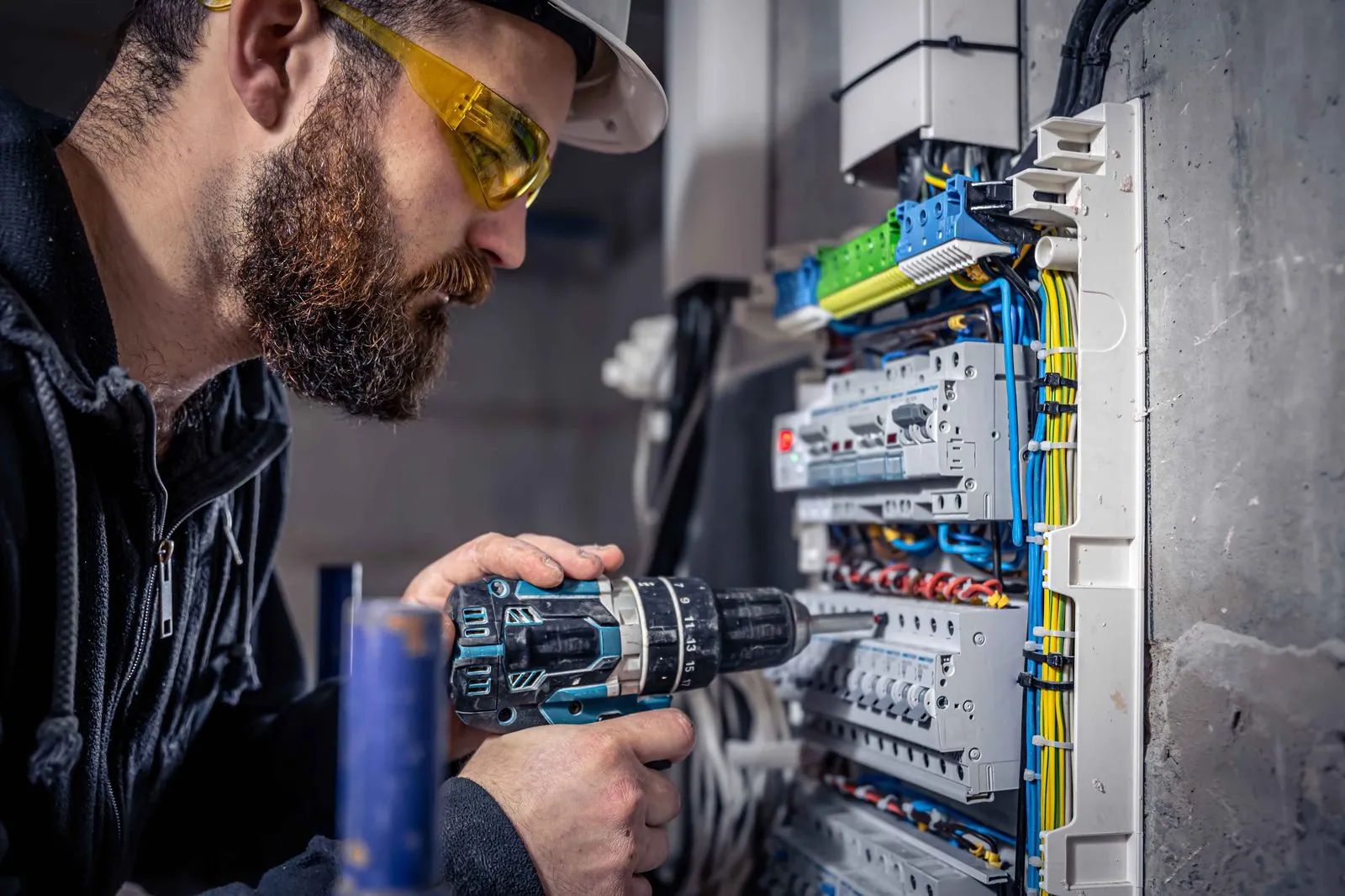 Elektricien boort aan een verdeelkast — de mensen achter CloudDock